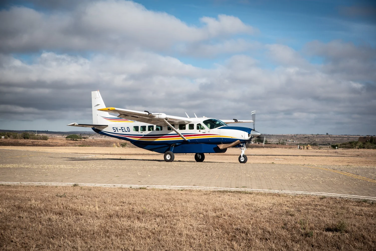 Cessna Caravan parked on an airstrip under a bright sky
