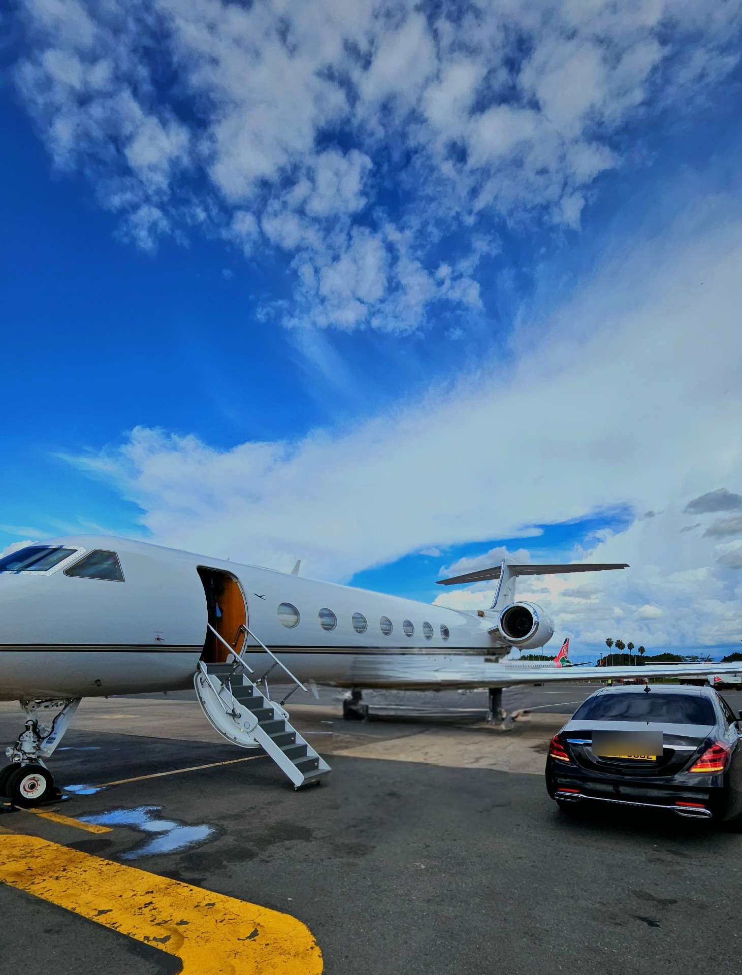 Gulfstream V private jet on the apron with vehicle registration obscured